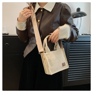 Modell mit beiger Cord-Minitasche, braunem Lederetikett und breitem Schultergurt