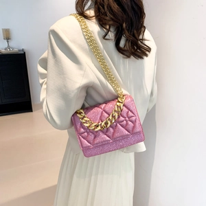 Pink sequin crossbody bag with quilted pattern and gold chain strap on model