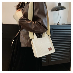 Detailaufnahme der beigen Cord-Mini-Tasche mit breitem Stoffriemen und Leder-Patch-Detail