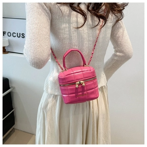 Détail du sac bandoulière matelassé rose avec chaîne dorée et lettrage mode