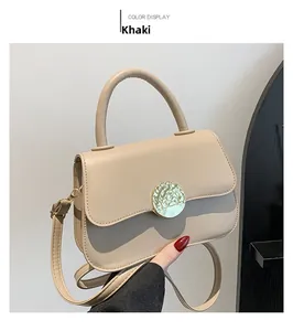 Detail of khaki leather shoulder bag with elegant gold circular metallic buckle