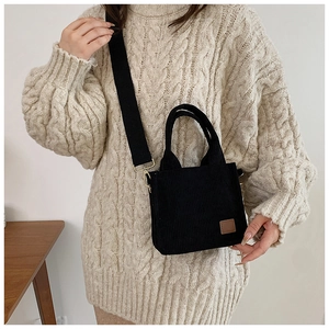 Retro-Umhängetasche aus schwarzem Cord mit braunem Lederpatch und breitem Tragegurt