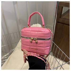 Détail du sac seau matelassé rose avec bandoulière chaîne et breloques sphères dorées