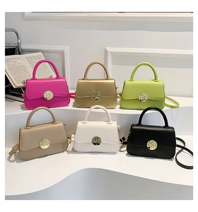 Collection of minimalist leather handbags in six vibrant colors displayed on white steps
