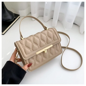 Quilted beige crossbody bag with gold hardware and top handle seen from a side angle