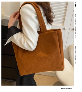 Brown corduroy tote bag shown on shoulder, highlighting its large capacity and soft texture