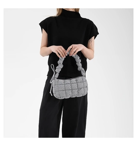 Detail of grey quilted cloud bag featuring a ruched handle and padded fabric texture