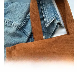 Detail showing the brown corduroy fabric and stitching on a large tote bag shoulder strap