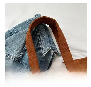 Detailed close-up of brown corduroy tote bag handle with striped texture and durable stitching