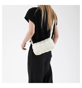 Detail of white quilted puffy cloud bag showing soft padded nylon texture and strap