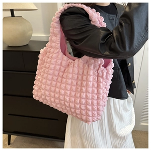 Detail of light pink popcorn textured tote bag showing 3D bubble fabric and soft handle