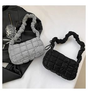 Close-up of quilted cloud armpit bags in silver and black with ruched scrunchie straps