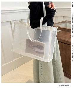 Detail of white mesh tote bag with wide straps and fashion card inside for spring 2025