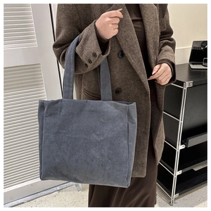 Detail of grey-blue corduroy tote bag showing ribbed texture and wide straps