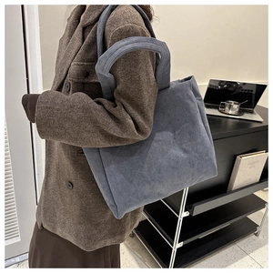 Detail showing the deep blue corduroy fabric texture and large capacity of this tote bag