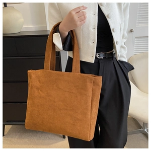 Brown corduroy tote bag shown on shoulder, showcasing its large capacity and retro casual style