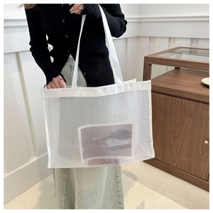 Detailed view of large white mesh tote bag showing breathable fabric and shoulder strap
