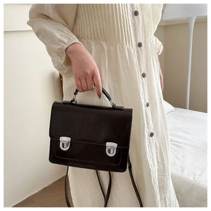 Detail of British style vintage messenger bag with silver metal buckles and top handle