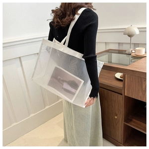 Detailed view of white mesh tote bag showing spacious capacity and sheer texture