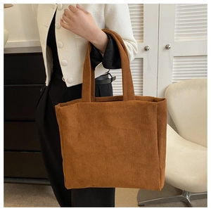 Close-up of brown corduroy tote bag showing soft ribbed texture and large capacity