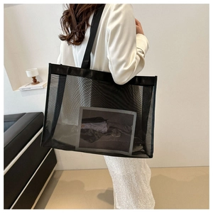 Detail view of a large black mesh tote bag showing its breathable fabric and spacious interior