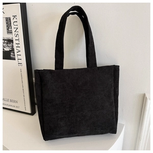 Detailed texture of black corduroy tote bag showing vertical ribbed fabric pattern