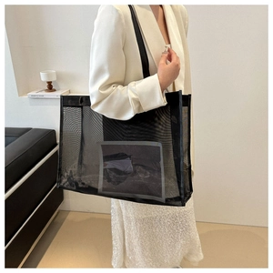 Detail of black mesh tote bag with wide webbing handles and internal pocket for storage