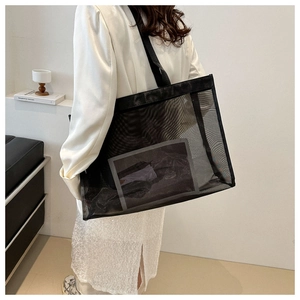 Modern black mesh tote bag on model showing spacious interior for summer travel