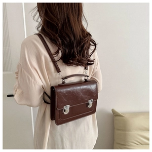 Detail of dark brown vintage faux leather satchel showing adjustable straps and stitching