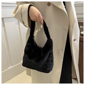 Détail d'un sac à main en fausse fourrure noire avec texture douce et poignée chic