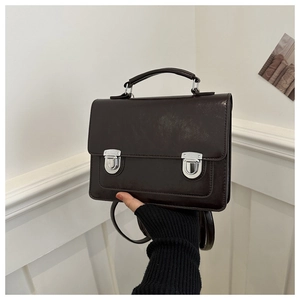 Detail of vintage brown British style leather satchel showing metal buckles and handle