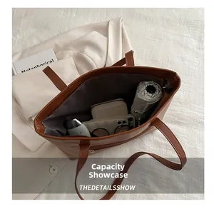 Spacious interior of brown leather tote bag showing umbrella, wallet and sunglasses