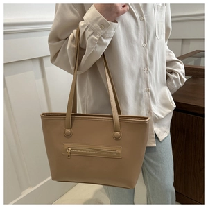 Model wearing a khaki PU leather tote bag with front zipper pocket for daily commuting