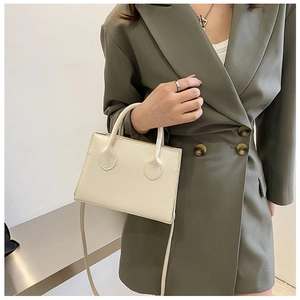 Petit sac à main blanc crème pour femme porté avec une tenue de bureau élégante