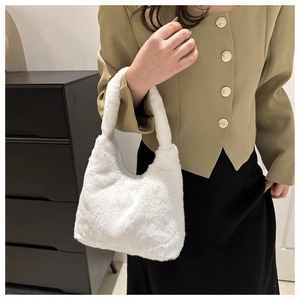 Sac en fausse fourrure blanche porté par un mannequin, texture douce et forme lune