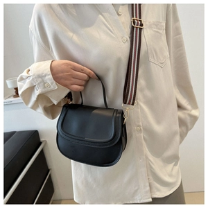 Minimalist black leather saddle bag with striped wide shoulder strap and top handle