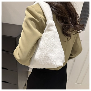 Side view of white faux fur tote bag showing soft texture on a camel blazer