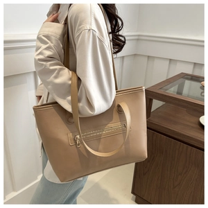 Dettaglio borsa shopper beige capiente con trama in pelle e cerniera dorata decorativa
