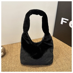 Gros plan sur la texture en peluche noire douce et l'anse du sac à main hobo