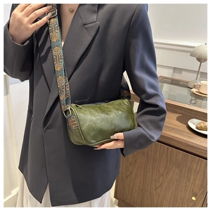 Sac cylindre vert rétro avec bandoulière jacquard ethnique dans un décor chaleureux