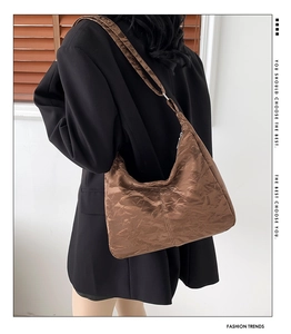 Sac hobo marron avec texture plissée porté par un mannequin en vue latérale