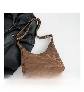 Détail du sac bandoulière marron avec texture plissée rétro et bandoulière réglable