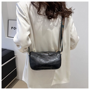 Nahaufnahme einer schwarzen Vintage-Pilllow-Bag mit einem stilvollen Jacquard-Gurt