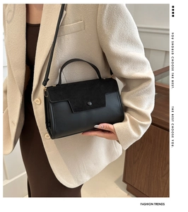 Detail of a chic black mixed-texture handbag paired with an oatmeal wool blazer coat