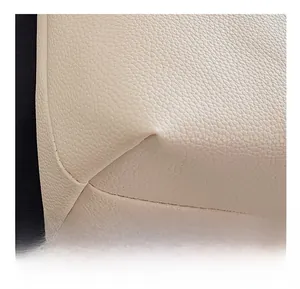 Macro shot of precise stitching and litchi texture on beige retro tote bag bottom corner