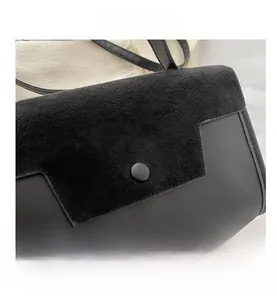 Close-up of black leather patchwork handbag with matte finish and stylish round clasp