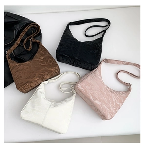 Détail de la texture plissée brillante sur les sacs demi-lune en quatre couleurs