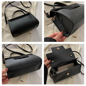 Detail of black faux suede crossbody bag with gold hardware and interior storage space
