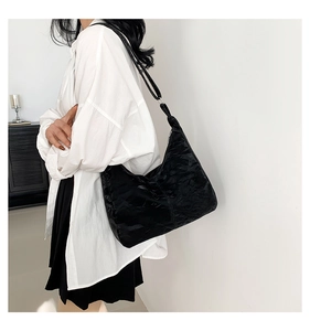 Détail du sac hobo avec grande capacité et texture plissée noire sur le cuir