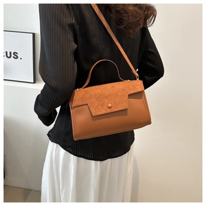 Minimalist tan suede-leather contrast handbag worn as a stylish crossbody shoulder bag